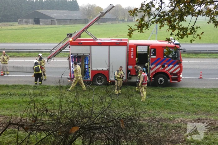 Brandweer blust brand naast snelweg