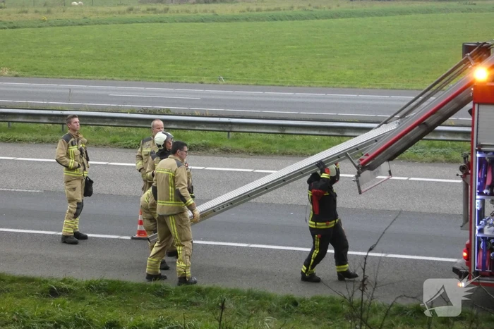 Brandweer blust brand naast snelweg
