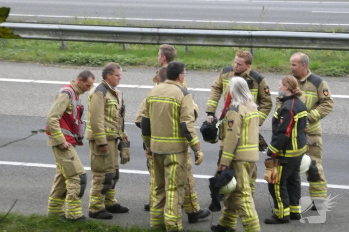 Brandweer blust brand naast snelweg