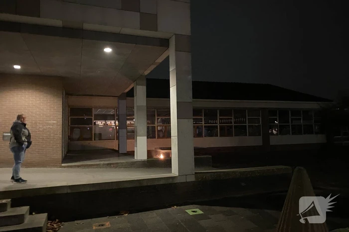 Brandweer blust brandende hoop kranten op schoolplein