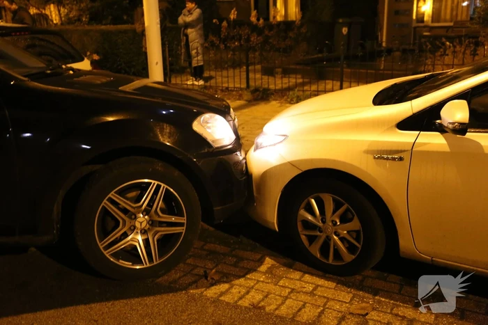 Automobilist krijgt lekke band en botst op geparkeerde auto's