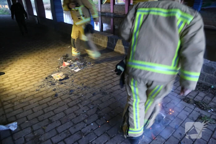 Brandweer dooft brandende reclamefolders