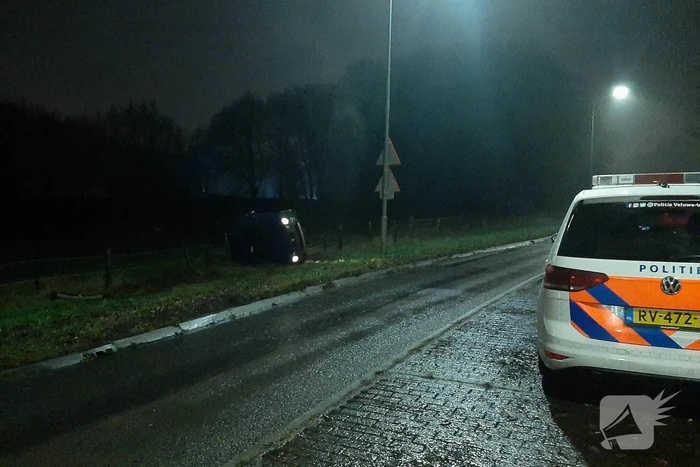 Auto op z'n zijkant naast de weg