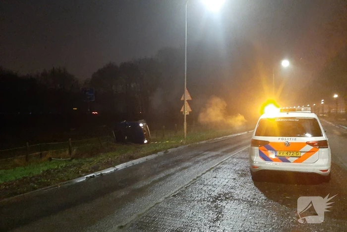 Auto op z'n zijkant naast de weg