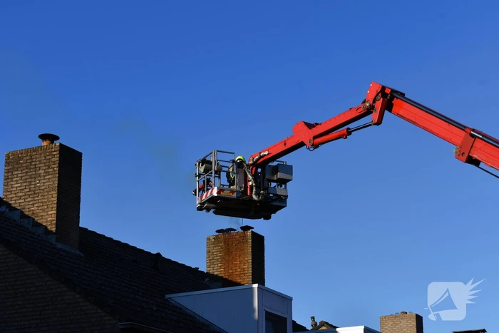 Brandweer veegt schoorsteen na brand