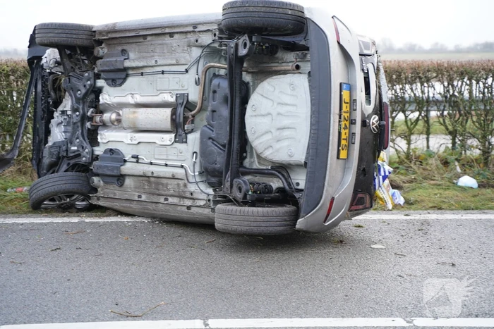 Auto op zijn kant bij verkeersongeval