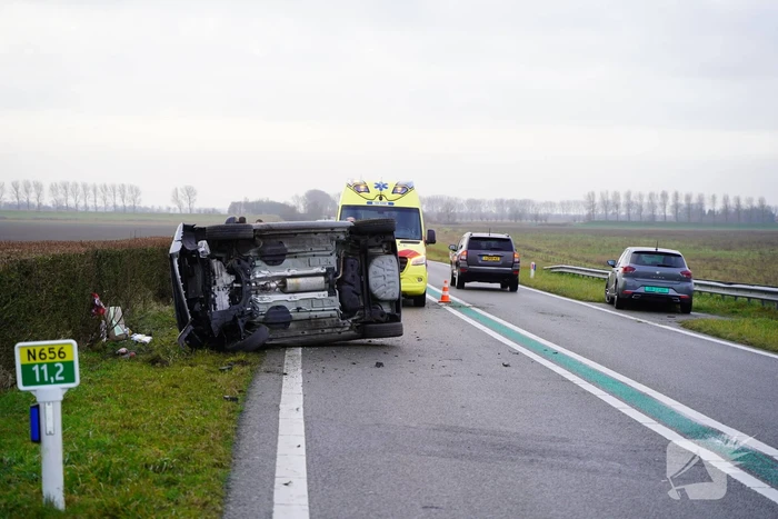 Auto op zijn kant bij verkeersongeval