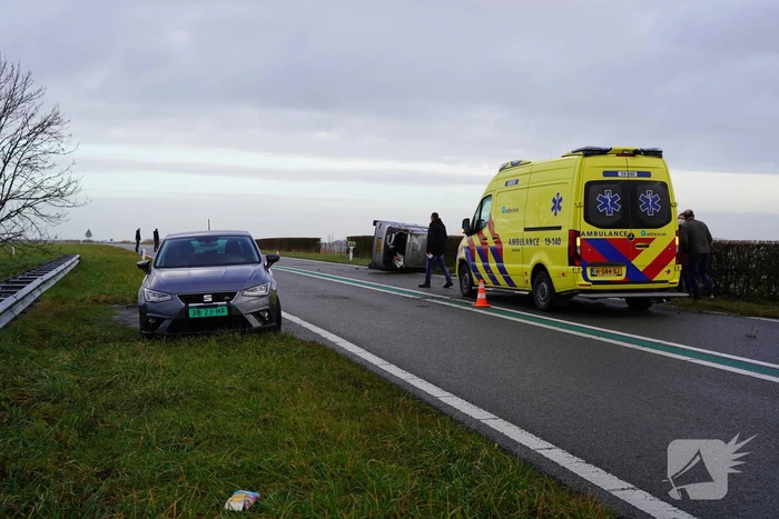 Auto op zijn kant bij verkeersongeval