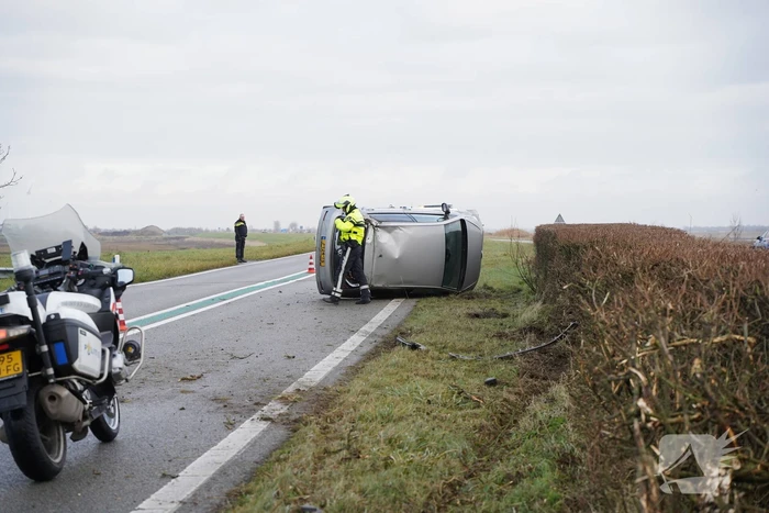 Auto op zijn kant bij verkeersongeval