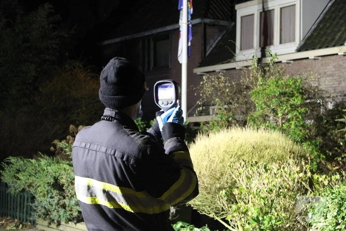 Brandweer breekt schoorsteen open na brandlucht