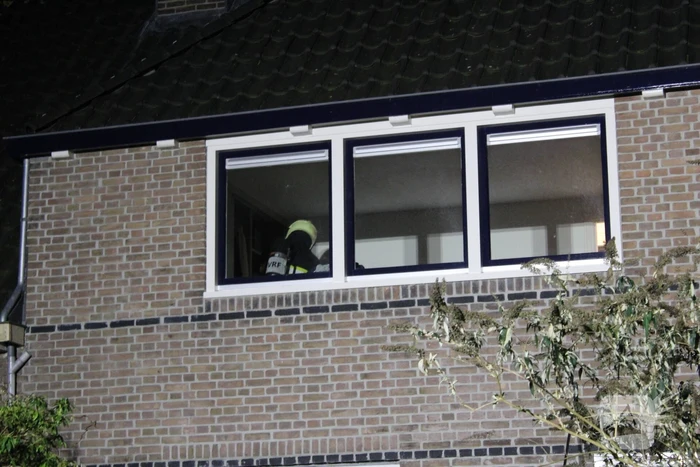 Brandweer breekt schoorsteen open na brandlucht