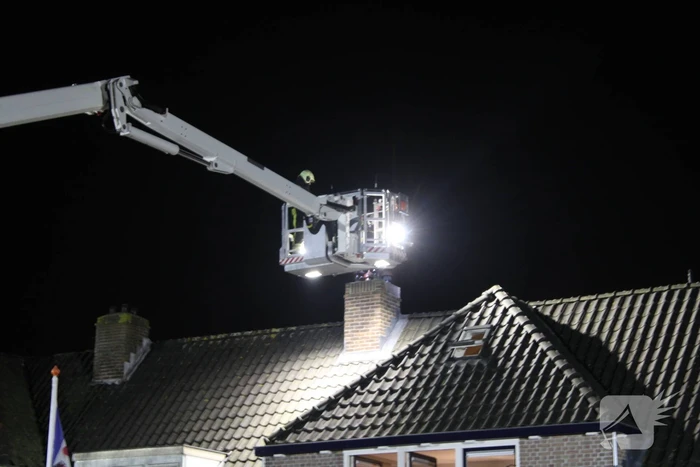 Brandweer breekt schoorsteen open na brandlucht