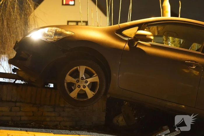 Auto belandt op betonnen muur van de brug