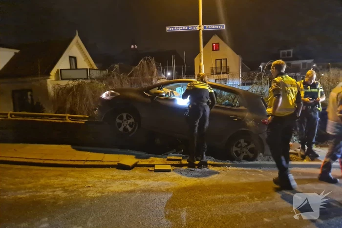 Auto belandt op betonnen muur van de brug