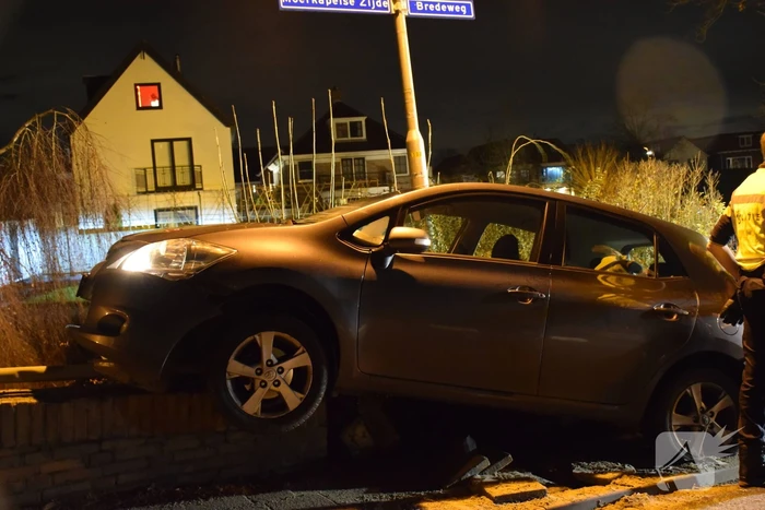 Auto belandt op betonnen muur van de brug