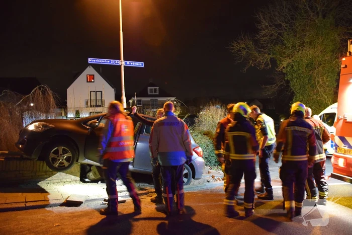 Auto belandt op betonnen muur van de brug