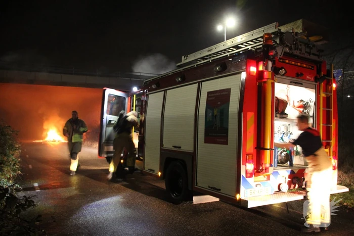 Stapel afval in brand onder brug over snelweg