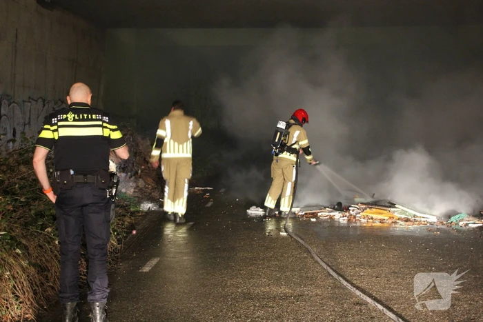 Stapel afval in brand onder brug over snelweg