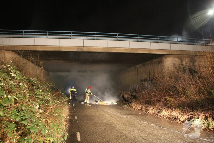 Stapel afval in brand onder brug over snelweg