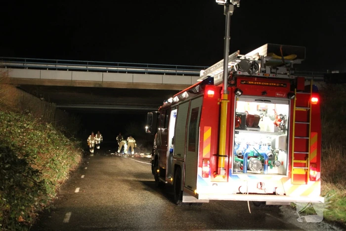 Stapel afval in brand onder brug over snelweg