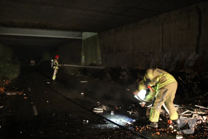 Stapel afval in brand onder brug over snelweg