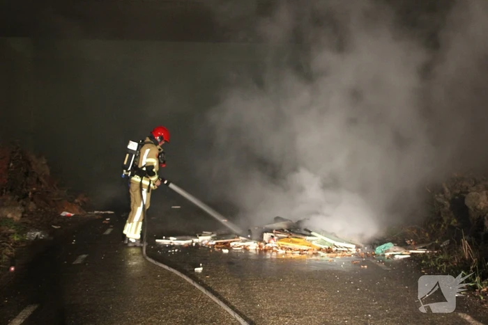 Stapel afval in brand onder brug over snelweg