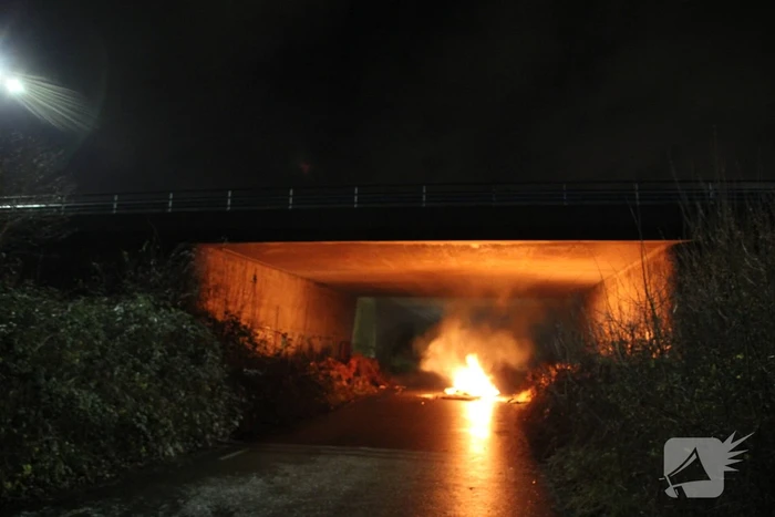 Stapel afval in brand onder brug over snelweg