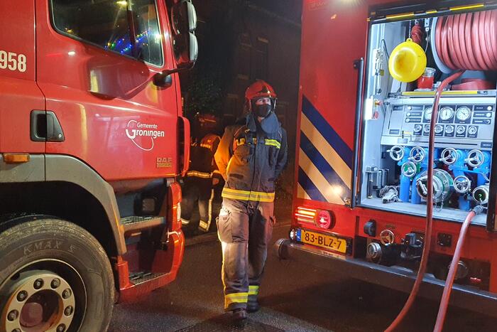 Brandweer blust brandend afval