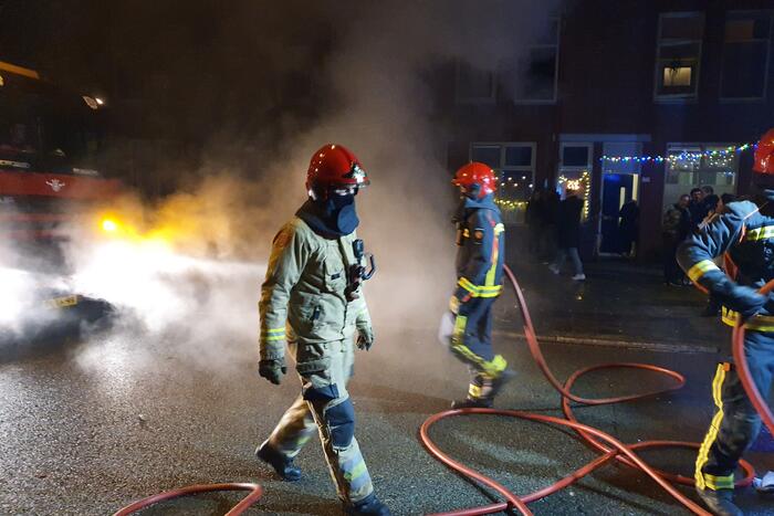 Brandweer blust brandend afval