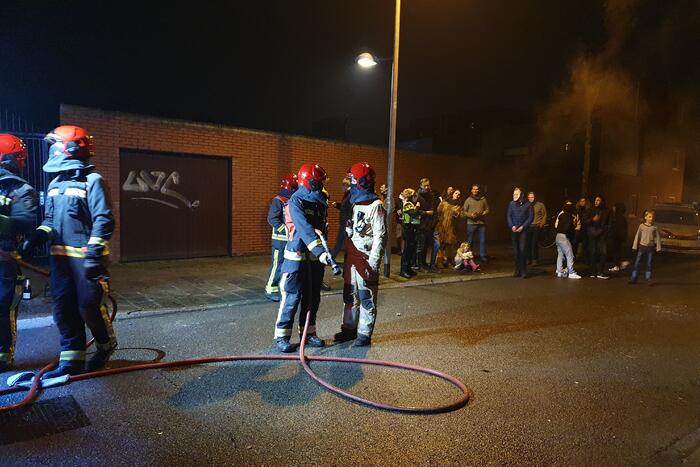Brandweer blust brandend afval