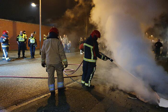 Brandweer blust brandend afval