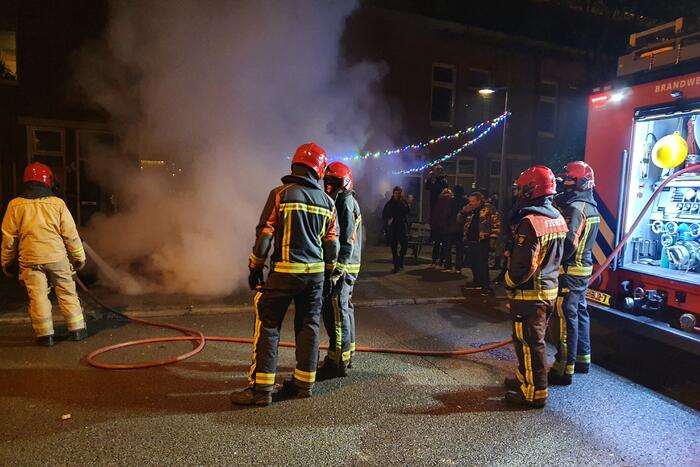 Brandweer blust brandend afval