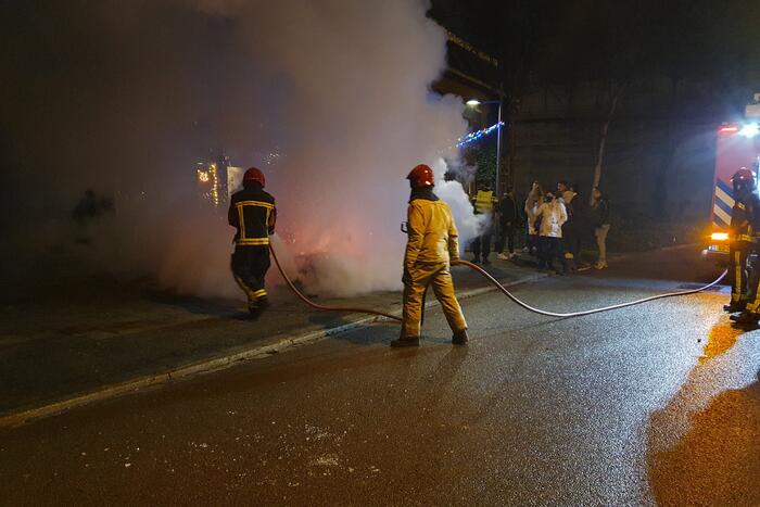 Brandweer blust brandend afval