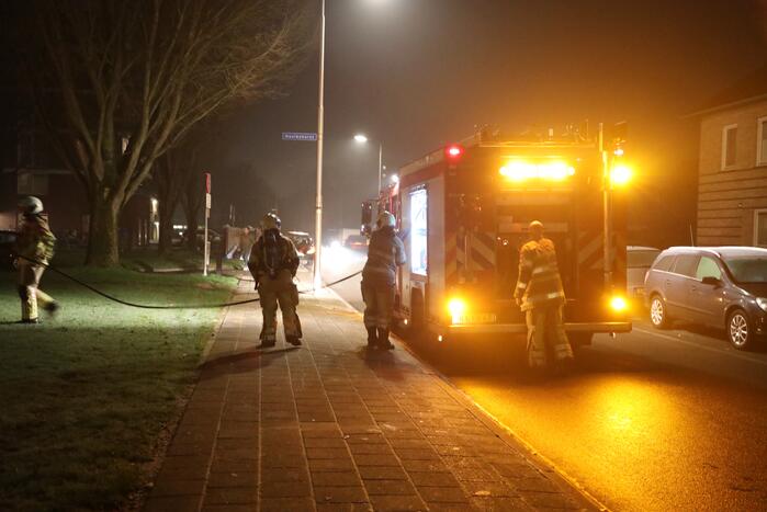 Hout en afval in brand tegen gevel