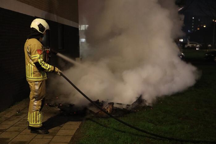 Hout en afval in brand tegen gevel