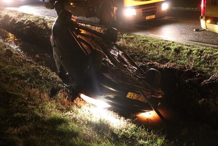 Auto belandt op dak in sloot