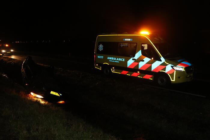 Auto belandt op dak in sloot