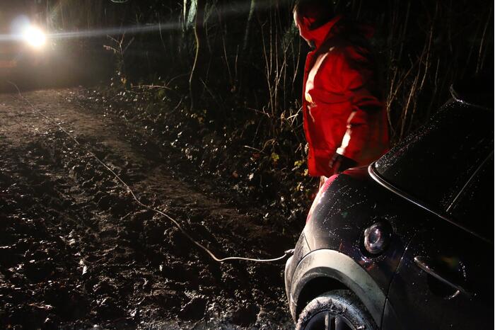 Auto rijdt zich vast in de modder