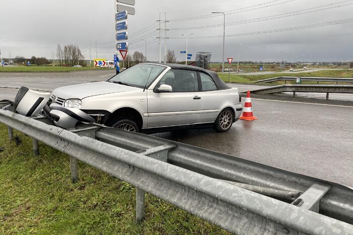 Auto belandt in vangrail