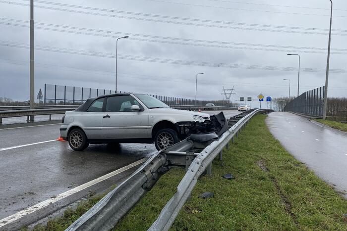 Auto belandt in vangrail