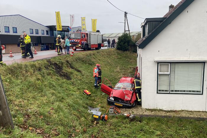 Auto rijdt van dijk en knalt tegen woning