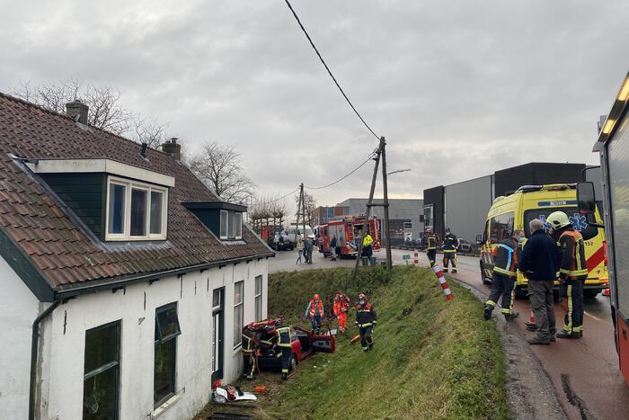 Auto rijdt van dijk en knalt tegen woning