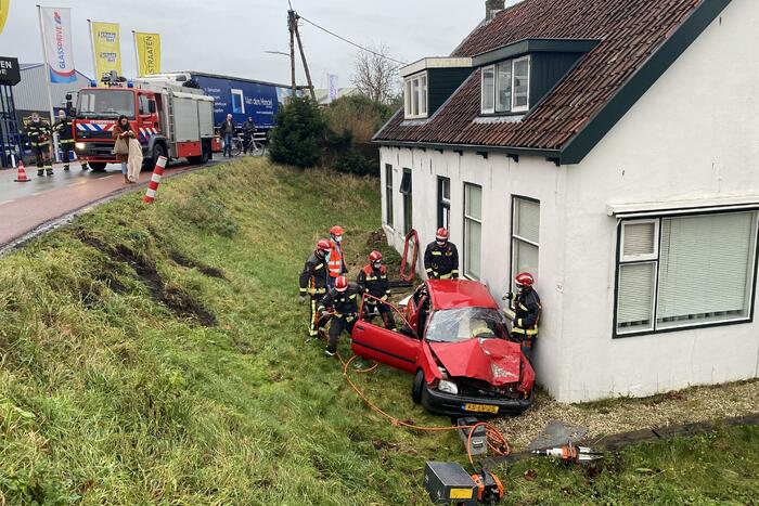 Auto rijdt van dijk en knalt tegen woning