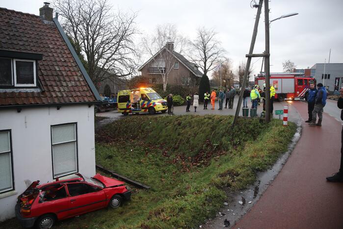 Auto rijdt van dijk en knalt tegen woning