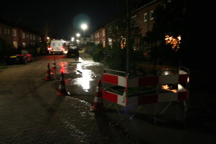 Straat onder water door gesprongen waterleiding