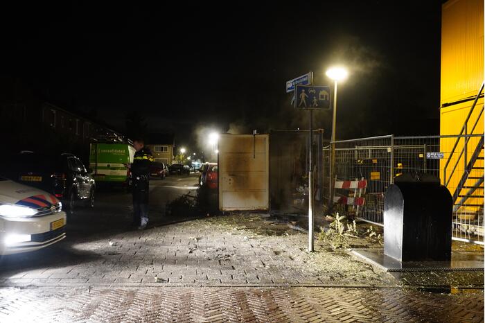 Kerstbomen tegen bouwcontainer in brand gestoken