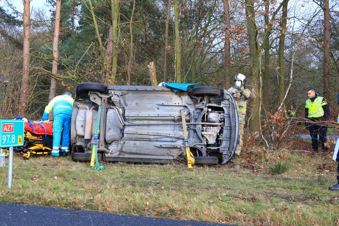 Auto vliegt uit de bocht en belandt op zijn kant