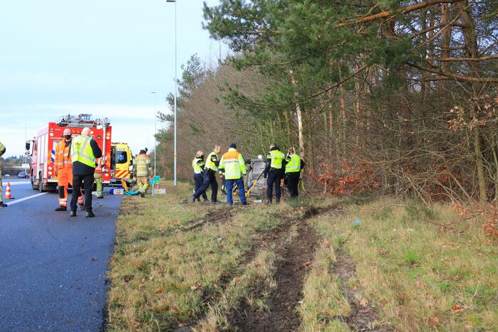 Auto vliegt uit de bocht en belandt op zijn kant