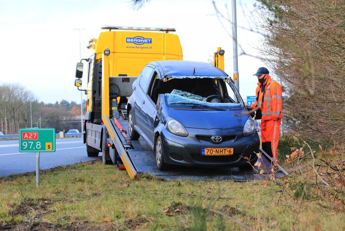 Auto vliegt uit de bocht en belandt op zijn kant