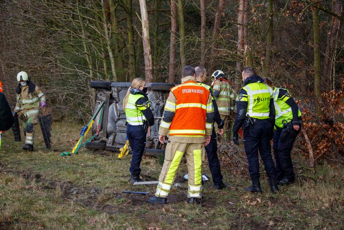 Auto vliegt uit de bocht en belandt op zijn kant